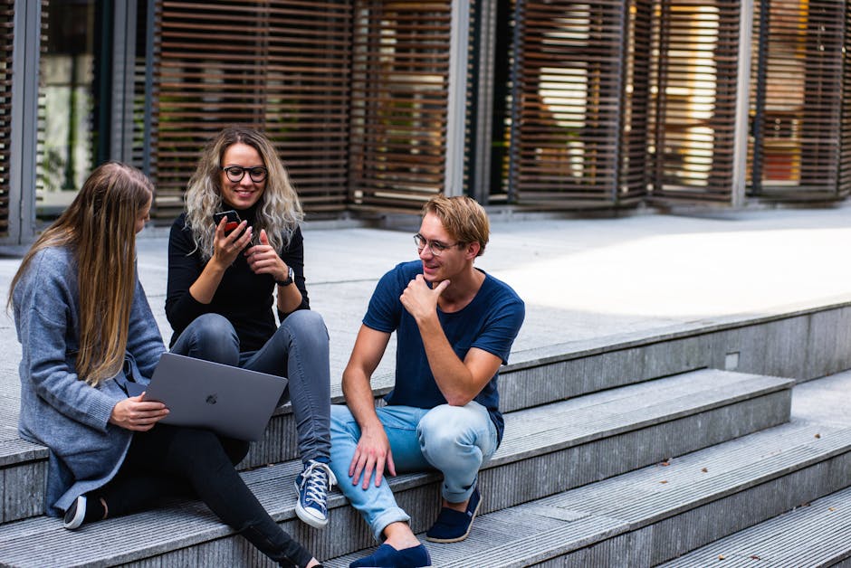 pexels photo 1438072 1438072 1 Three young professionals having a friendly chat while sitting on outdoor steps.